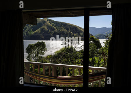 View through a window over a balcony to the Wuakapuaka estuary in New Zealand. Stock Photo