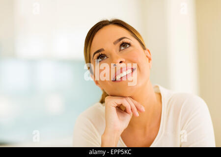 thoughtful young woman looking up Stock Photo