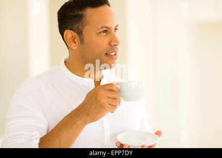 thoughtful man having cup of coffee indoors Stock Photo