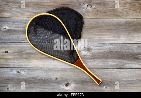 Landing net for trout fishing on rustic wooden boards. Stock Photo