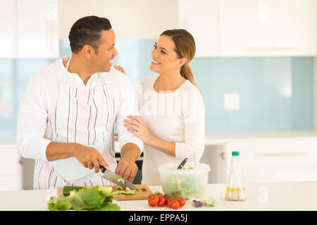 romantic middle aged couple in kitchen cooking food Stock Photo