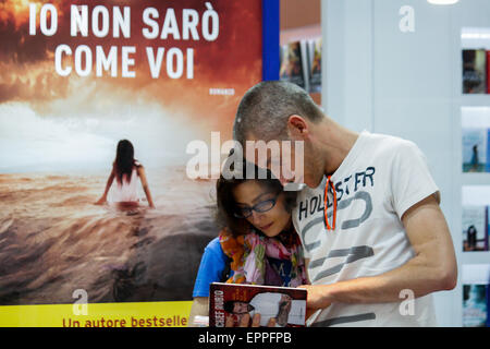 Turin, Italy. 20th May, 2015. The 28th International Book Fair of Turin has recorded 341,000 admissions, with Germany as Guest Country of Honor. A couple consult the book by the Chef Rubio. © Elena Aquila/Pacific Press/Alamy Live News Stock Photo