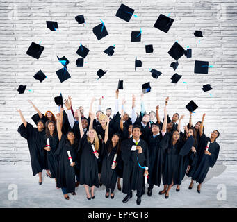 Group of cheerful graduates celebrating their graduation by forming a ...