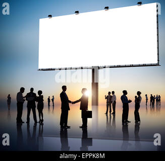 Group Of Business People Silhouettes Outdoors And An Empty Billboard Above Stock Photo