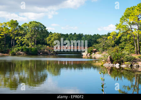 Florida , Del Ray Beach , Morikami Museum & Park , Roji-En , Japanese Gardens of Drops of Dew water lake trees & red bridge Stock Photo