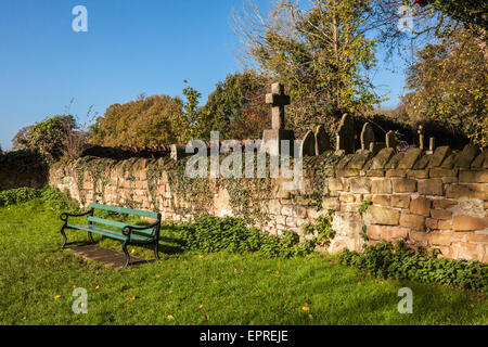 Peaceful bench next to the Graveyard wall in Abbey Fields, Kenilworth, Warwickshire, UK Stock Photo