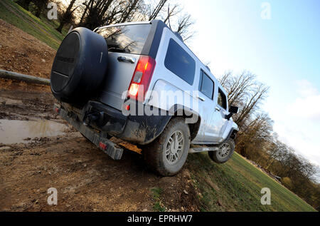 Hummer H3 driving off road and lifting a wheel Stock Photo