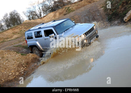 Hummer H3 driving off road splashing through deep water Stock Photo
