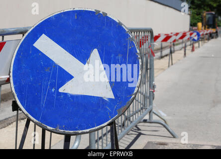 big road signal with arrow on the excavation during the roadworks for the laying of fiber optical Stock Photo