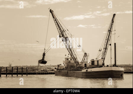 Effect vintage. Small dredge marine, which is cleaning a navigation channel Stock Photo