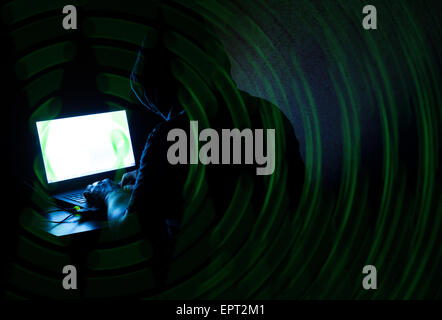 Hooded unknown man stealing data from the Internet Stock Photo