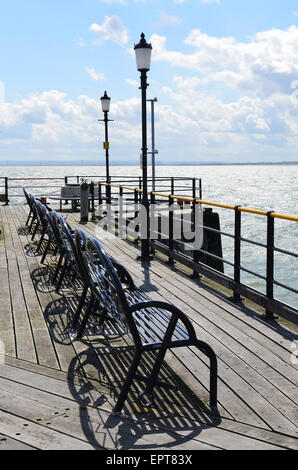 Row of wrought iron benches at the end of Southend pier in Essex, England. Stock Photo