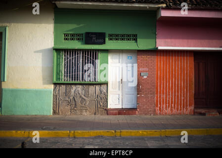 Casa Museo Egyptian Carving Green Colonial Facade Calle La Calzada Granada Nicaragua | GRANADA, Nicaragua — An Egyptian-motif bas-relief carving sits beneath a barred window on the green facade of a Casa Museo along Calle La Calzada. The pharaonic panel is an eclectic outlier among the city's Spanish colonial buildings, reflecting the syncretic architectural fashions that wealthy Granada merchants embraced in the late 19th and early 20th centuries. Founded in 1524, Granada is among the oldest European-established settlements in the Americas. Stock Photo