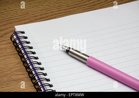 Pink fountain pen on blank white lined notebook Stock Photo