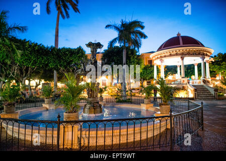 GRANADA, Nicaragua — A fountain and pergola stand in the middle of Parque Central at dusk. Parque Central is the main square and the historic heart of Granada, Nicaragua. Stock Photo