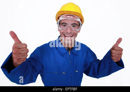 Elated tradesman giving two thumb's up Stock Photo