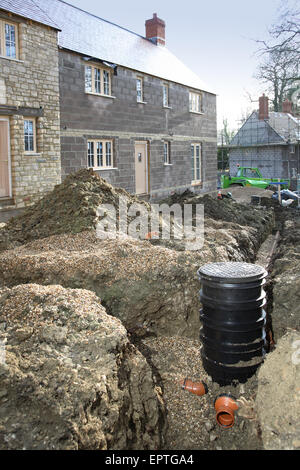 Plastic underground drainage pipes and inspection chamber during installation on a, rural housing development in Dorset, UK Stock Photo