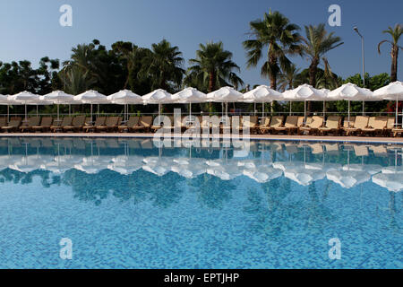 Chairs and umbrellas near swimming pool Stock Photo