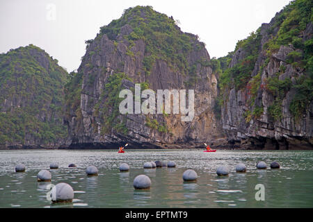 Kayaking past a pearl farm in Halong Bay Stock Photo
