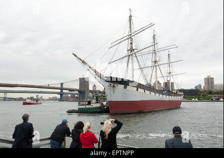 New York, USA. 21st May, 2015. Tugboats pulled and pushed the South Street Seaport Museum's ship, Wavertree, away from Pier 15 into the East River for her trip to Caddell's Dry Dock in Staten Island. Wavertree, an iron-hulled sailing ship, was built in Liverpool, England in 1885 to serve as a cargo ship. The last iron-hulled sailing ship afloat, she is about to undergo a year-long, $10.6 million restoration and stabilization. Credit:  Terese Loeb Kreuzer/Alamy Live News Stock Photo