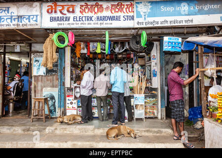 Mumbai India,Indian Asian,Dharavi,Shahu Nagar Road,small businesses,adult adults man men male,electric hardware store,stray dog dogs,dogs,Hindi Englis Stock Photo