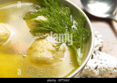 Delicious Matzoh ball soup with crackers wine and dill Stock Photo