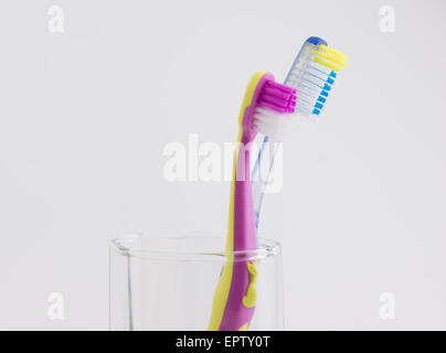 big and small toothbrushes in a glass photographed on a white background Stock Photo