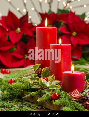 Lit red candles in an evergreen Christmas arrangement Stock Photo