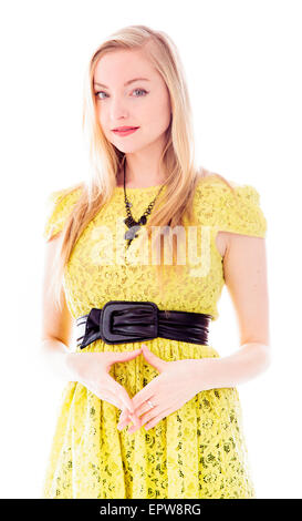 Beautiful young woman standing and making heart shape with her hands Stock Photo