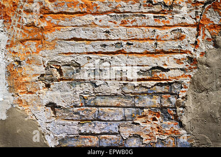 Grunge texture of old brick with plaster falls off in the background Stock Photo