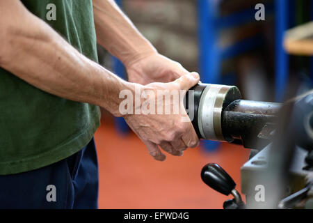 Close up of the hands of a man working on machinery in an engineering workshop or factory Stock Photo