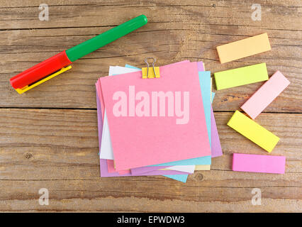 Colored stickers around notebook on old wooden table Stock Photo