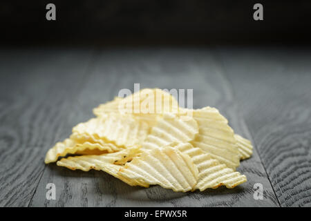 rippled organic chips on wooden table Stock Photo