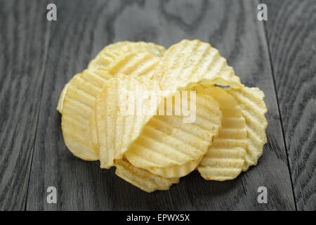 rippled organic chips on wooden table Stock Photo