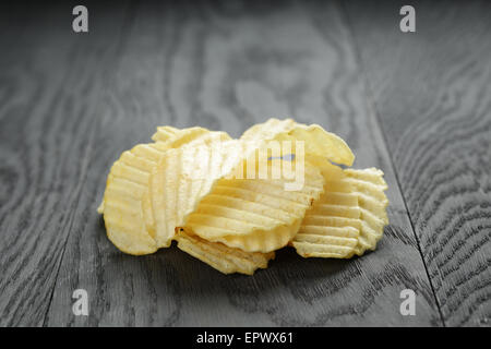 rippled organic chips on wooden table Stock Photo
