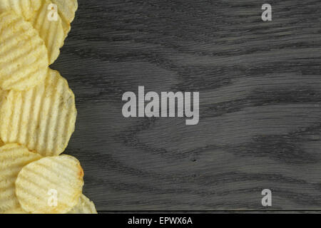 rippled organic chips border on wooden table Stock Photo