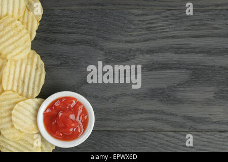 rippled organic chips border on wooden table Stock Photo