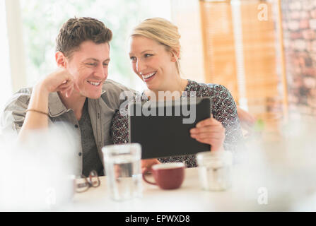 Couple using tablet pc in cafe Stock Photo
