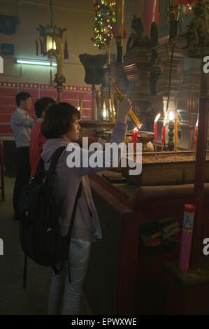 dh Man Mo Temple SHEUNG WAN HONG KONG Chinese woman joss sticks temple praying china taoism hold incense stick people inner