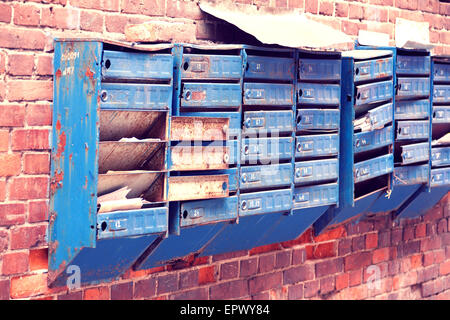 broken mailboxes on an old brick wall Stock Photo