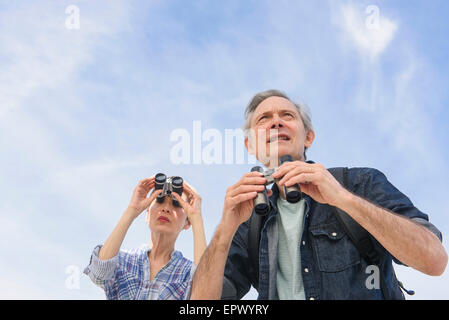 Senior couple watching birds with binoculars Stock Photo