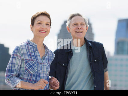 Smiling senior couple walking in city Stock Photo