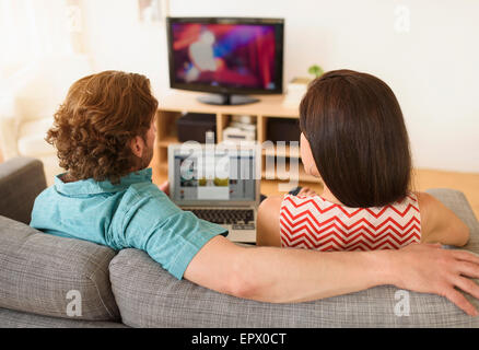 Couple using laptop on sofa Stock Photo