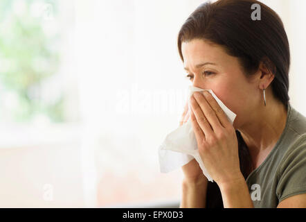Woman blowing her nose Stock Photo