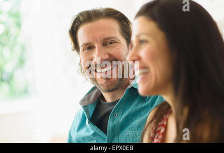 Portrait of man sitting with girlfriend on sofa Stock Photo