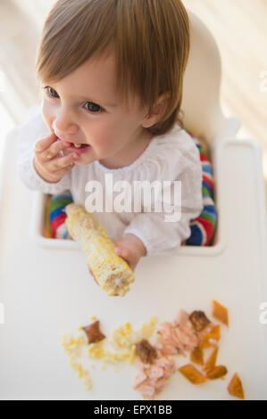 Girl (2-3) eating sweet corn Stock Photo