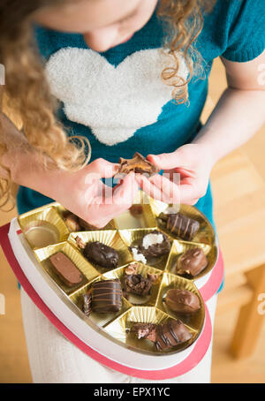 Girl (10-11) taking chocolate Stock Photo