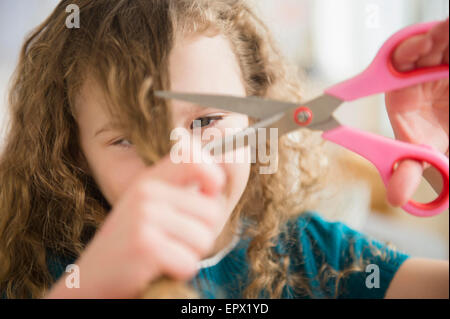 Girl (10-11) cutting her hair Stock Photo
