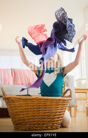 Girl (10-11) throwing up clothes Stock Photo