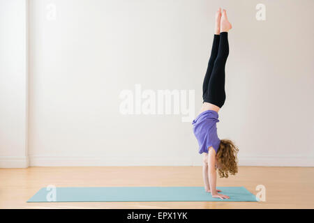 Girl (10-11) doing handstand